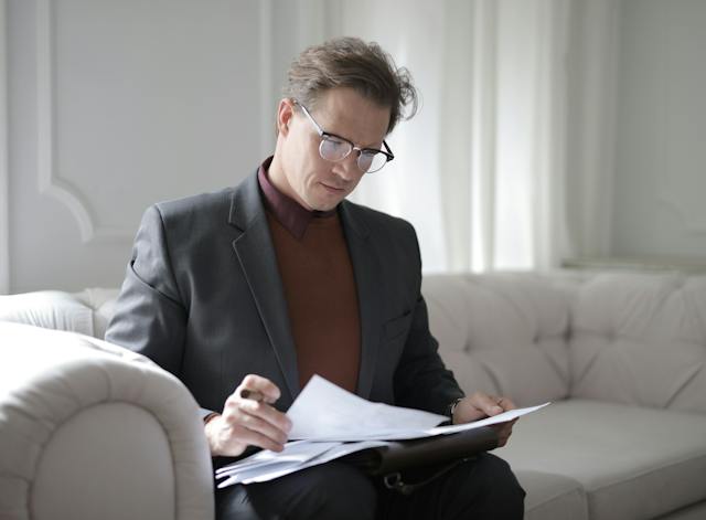 person wearing glasses while reviewing contracts
